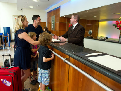 A family being served at a hotel counter